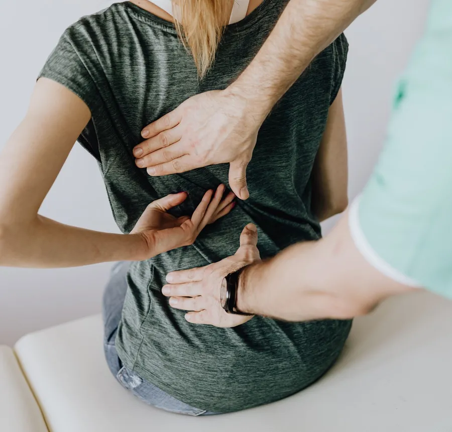 Patient pointing to a sore spot on her back during an exam