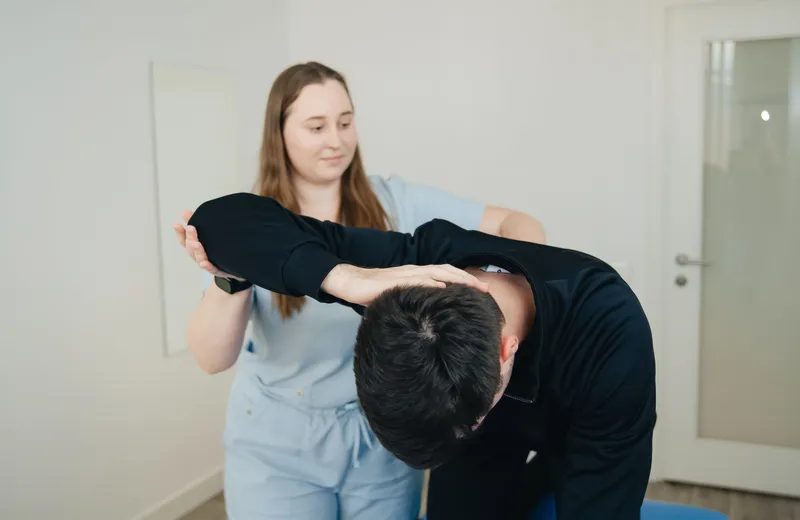 Patient doing a guided stretch with a practitioner
