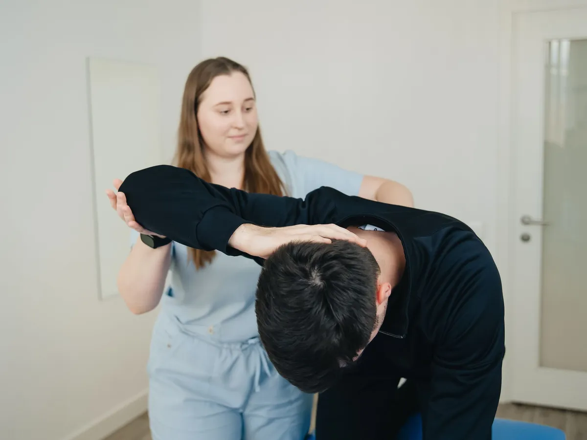 Patient doing a guided stretch with a practitioner