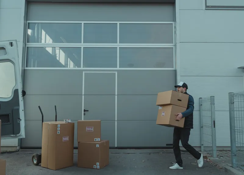 Worker carrying boxes at a loading dock