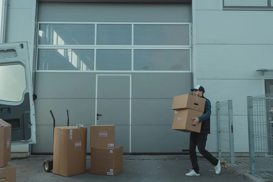 Worker carrying boxes at a loading dock