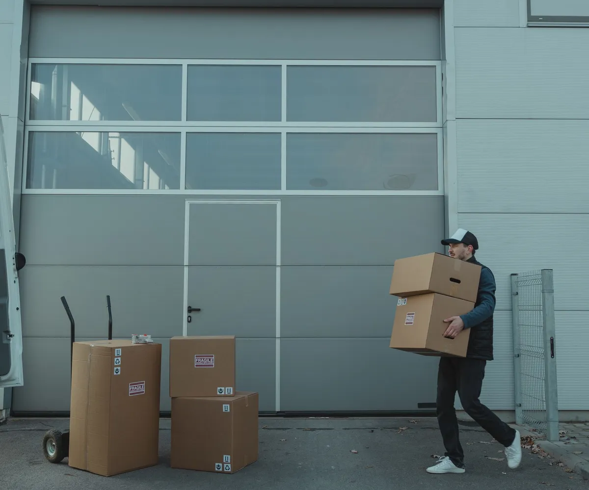 Worker carrying boxes at a loading dock