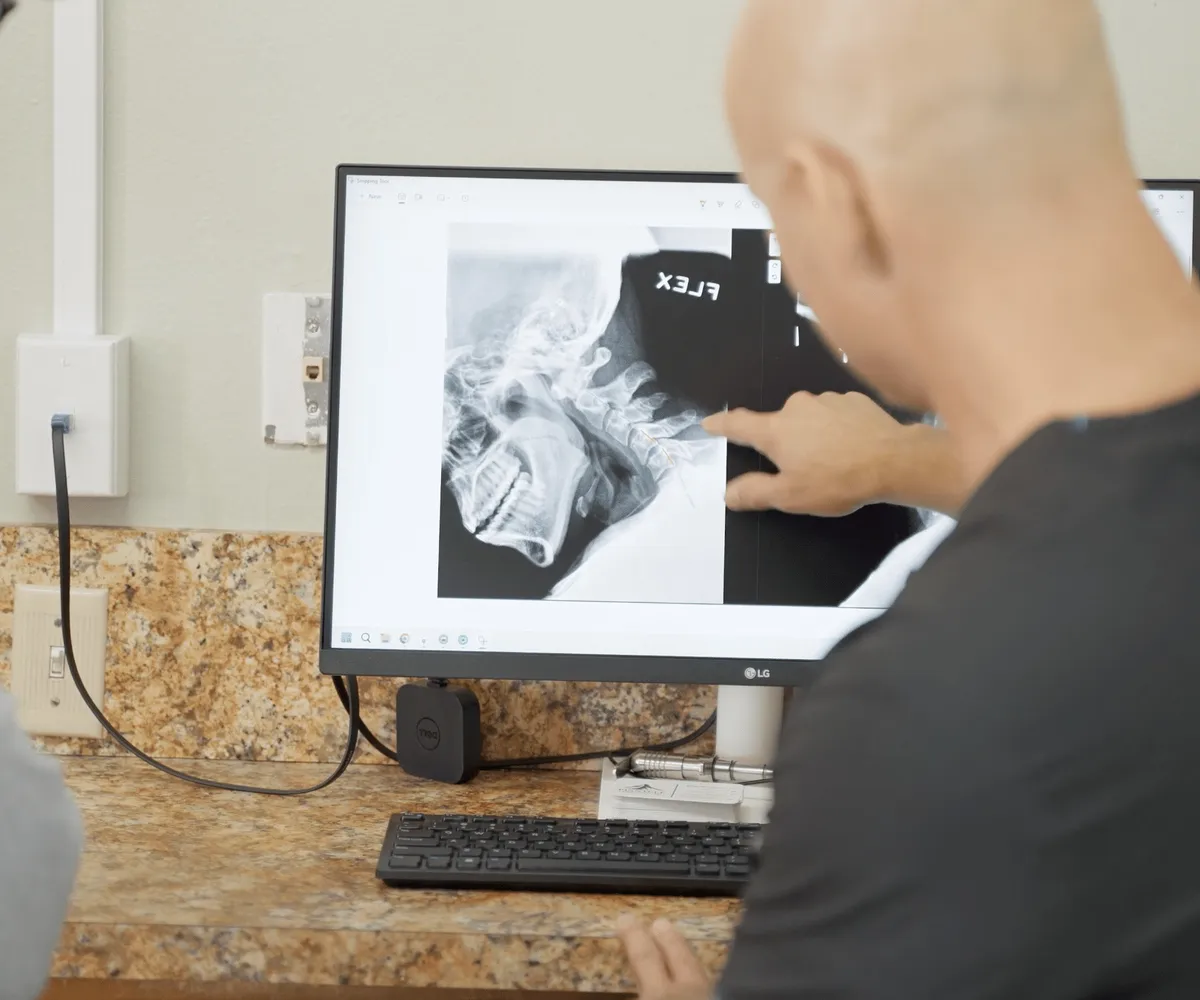 Dr. Woodbury reviewing a neck X-ray on screen with a patient