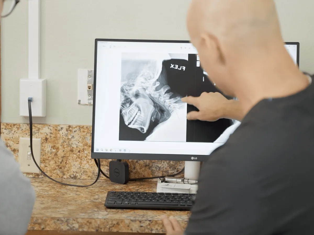 Dr. Woodbury reviewing a neck X-ray on screen with a patient