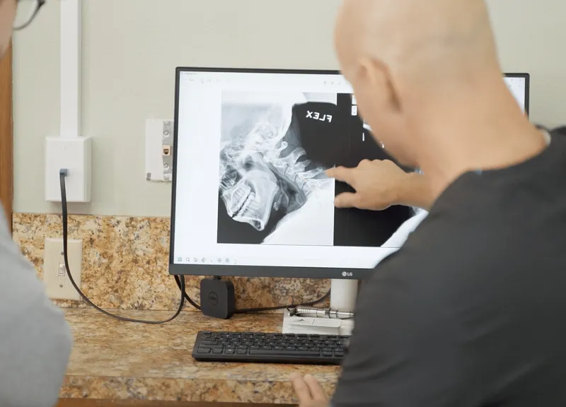 Dr. Woodbury reviewing a neck X-ray on screen with a patient