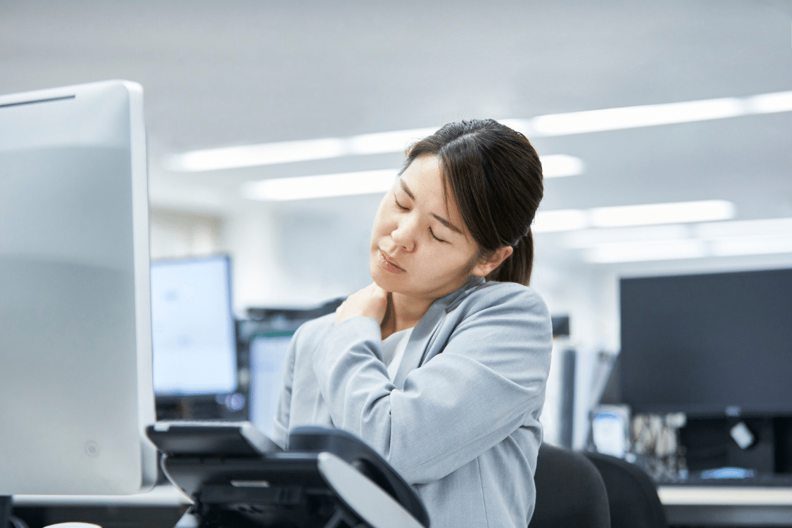 Woman experiencing neck pain sitting at desk